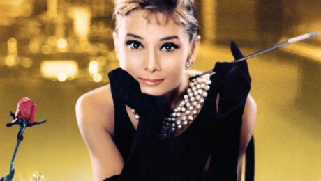 Audrey Hepburn as Holly Golightly in a black dress and pearl necklace