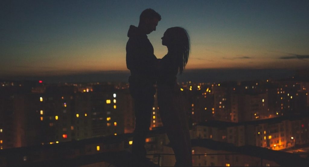 a couple on a roof having a multicultural romance