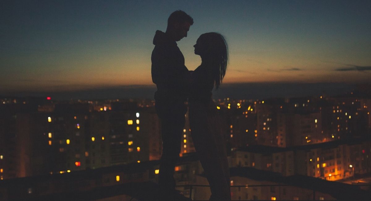 a couple on a roof having a multicultural romance