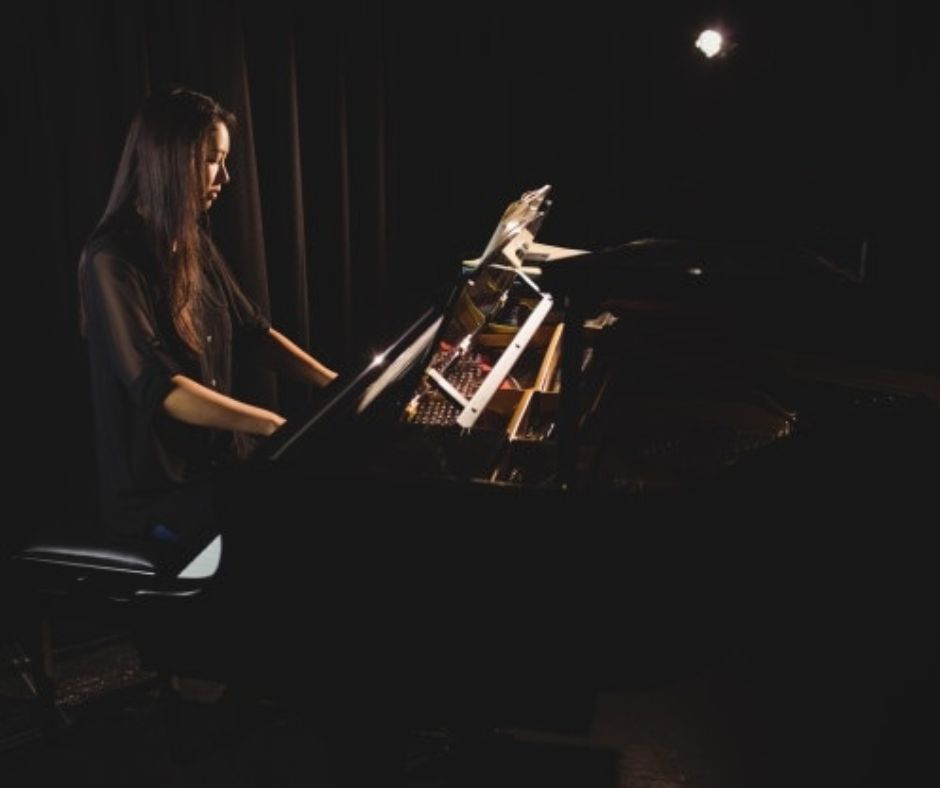 Clara Yehonala plays a piano in the darkness